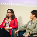 Two woman talking at a conference with microphones