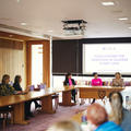 A masterclass session in progress showing speakers and attendees sat around desks interacting