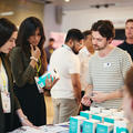 event attendees listening to a founder at their stand