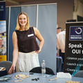 A smiling exhibitor stood at their stand