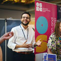 A smiling exhibitor at their stand