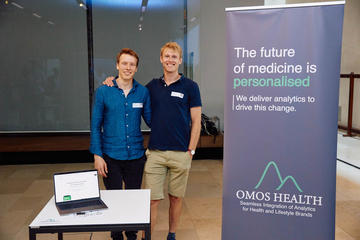 The Omos health team smiling and stood next to their stand