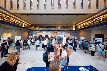 A wide shot of the Weston Library During Demo Night 2023 showing the startup stands and crowd members