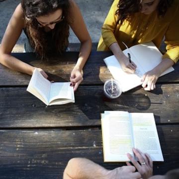 Birds eye view of three students working at a table with open books